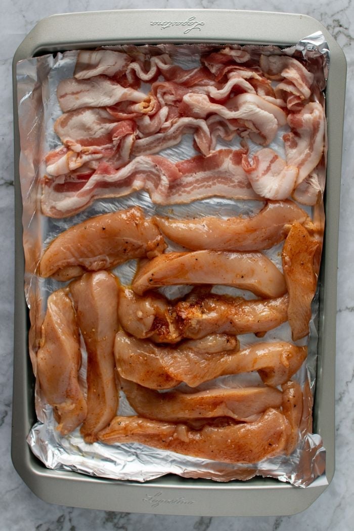bacon and chicken on a baking sheet
